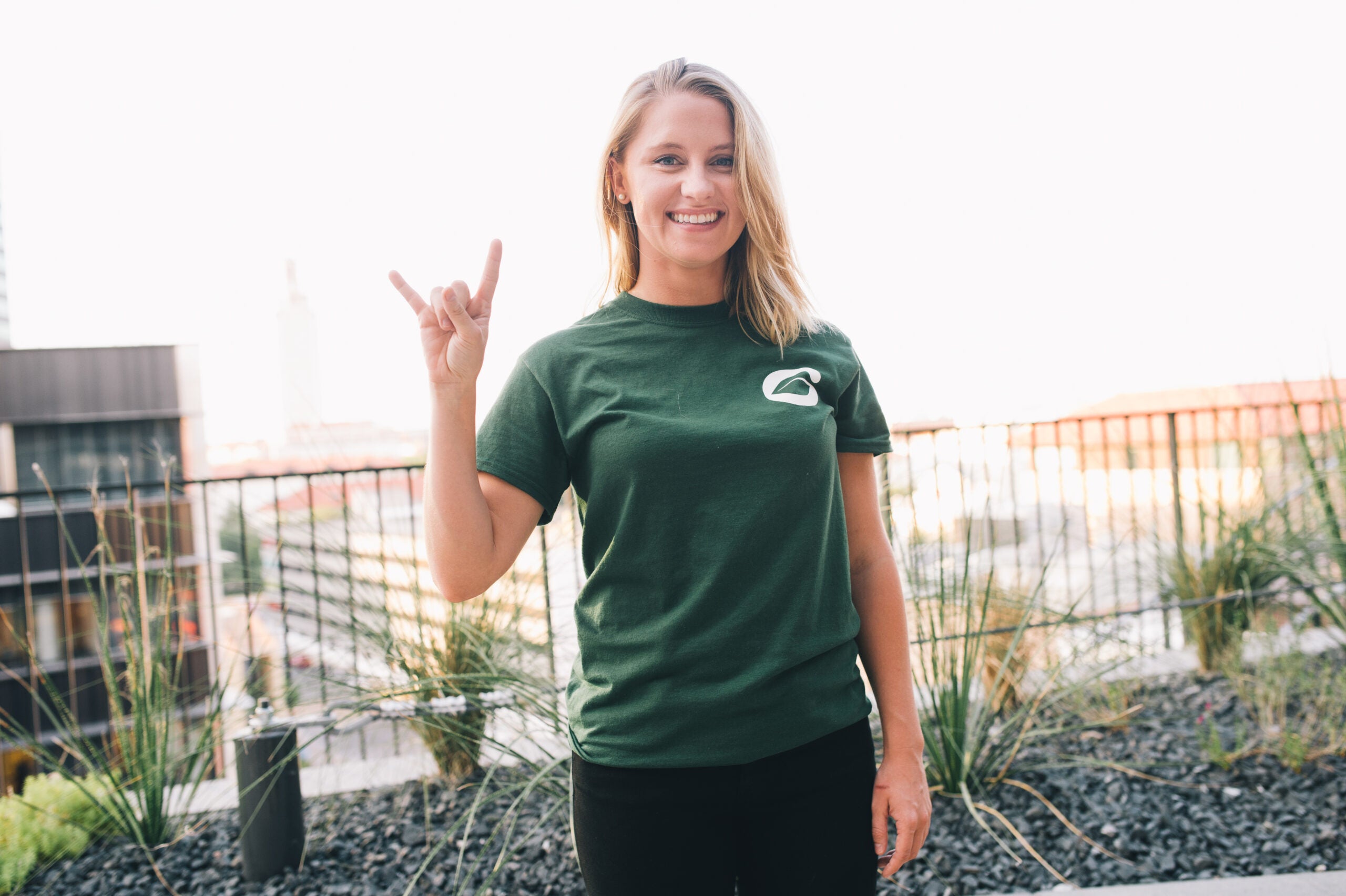 image of a woman in a green shirt doing hook 'em