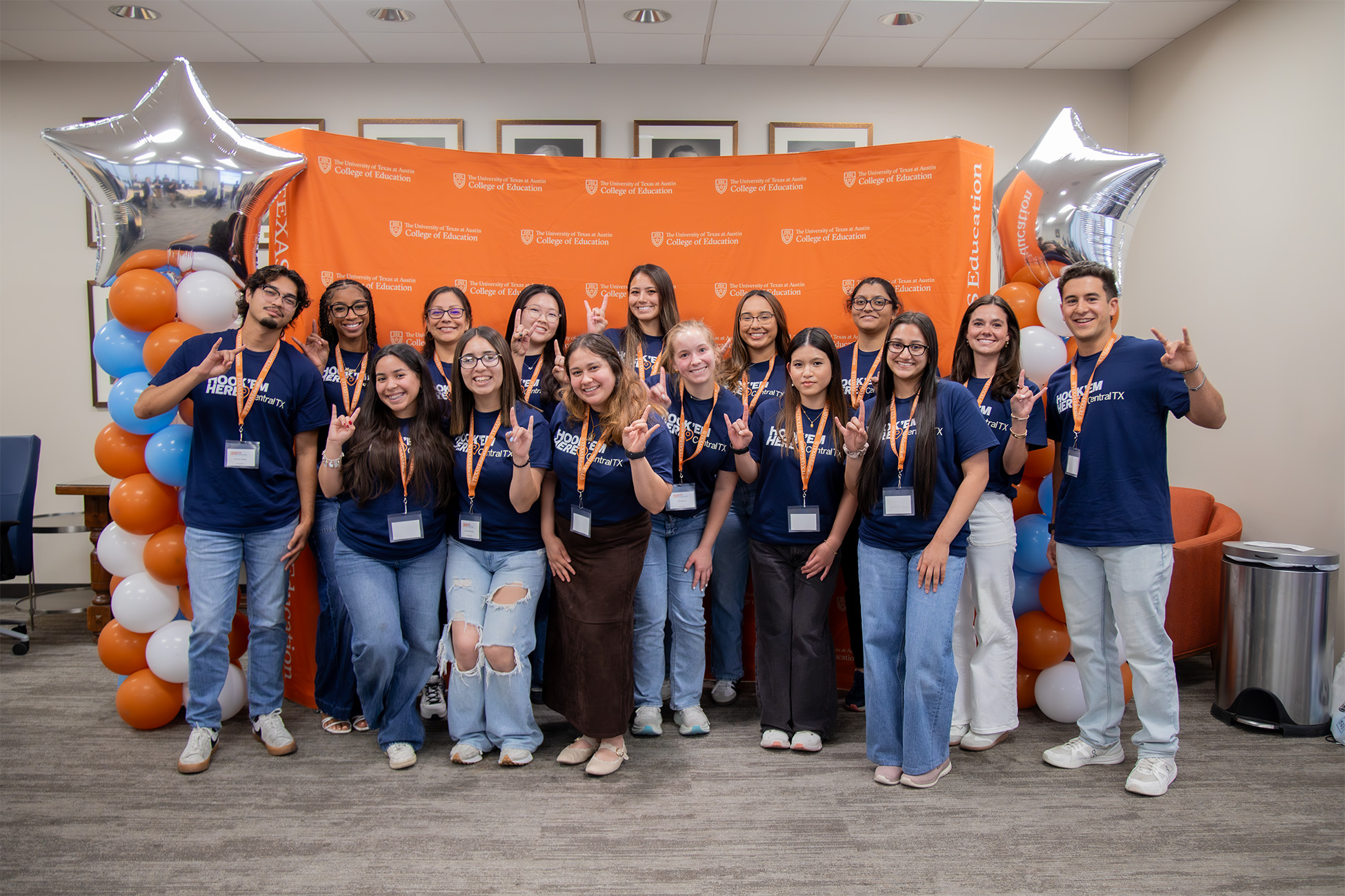 image of a group of students using hook 'em in front of a backdrop and balloons
