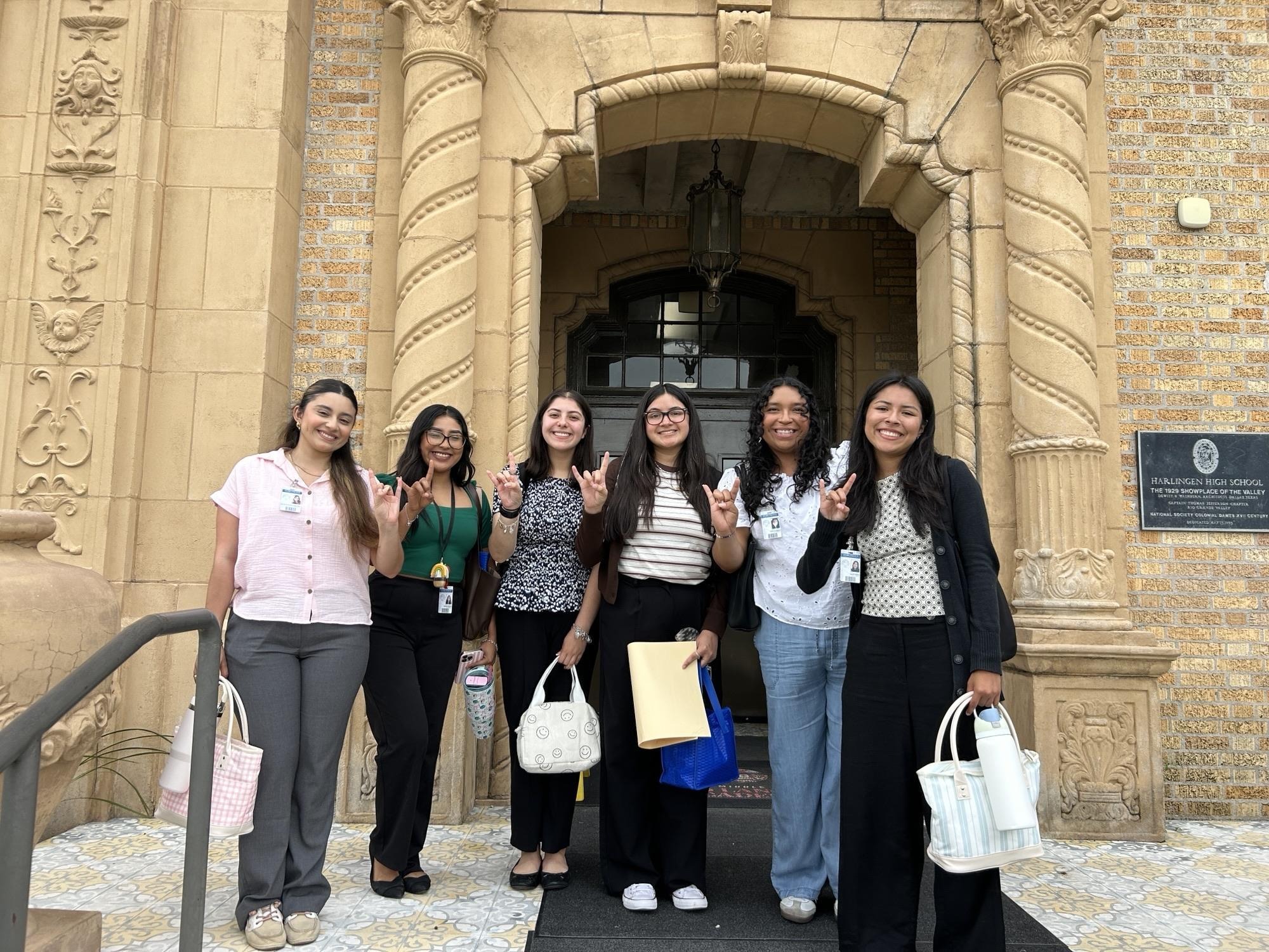 image of a group of students in front of a tan building