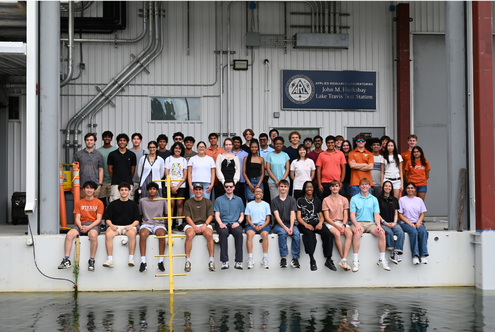 A large group of students poses for a photo at a lab.